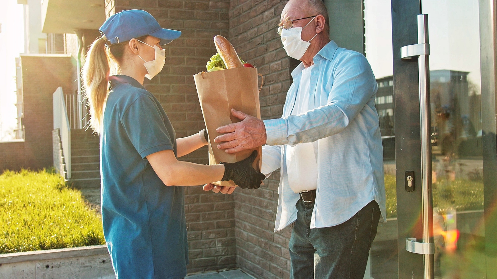 Delivery of food in quarantine. Senior man in protective mask customer receiving food bag.